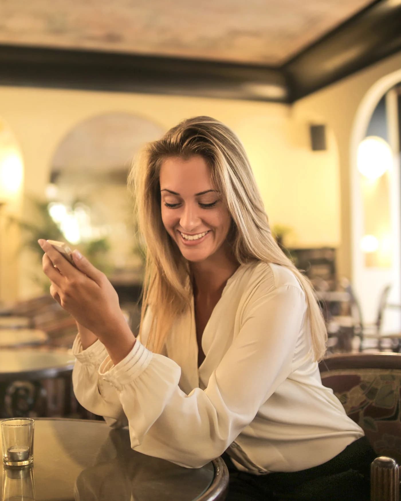 Vrouw die lachend op haar telefoon kijkt